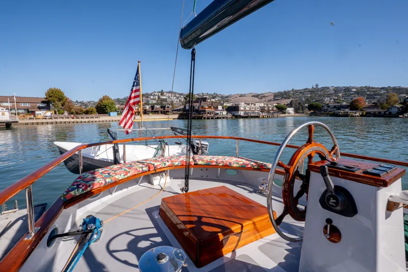 Slide: The Image of 1981 Thackwray Motorsailor boat with American flag, scenic waterfront view. - 23
