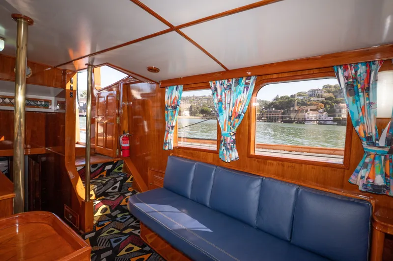 Slide: The Image of Interior of 1981 Thackwray Motorsailor with blue seating, colorful curtains, and wood paneling. - 122