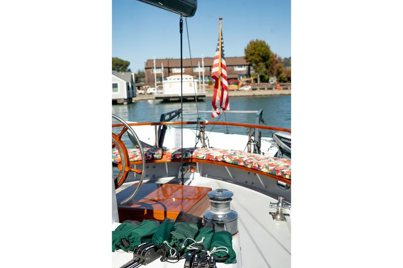 Slide: The Image of 1981 Thackwray Motorsailor boat deck with floral cushions and American flag in harbor. - 37
