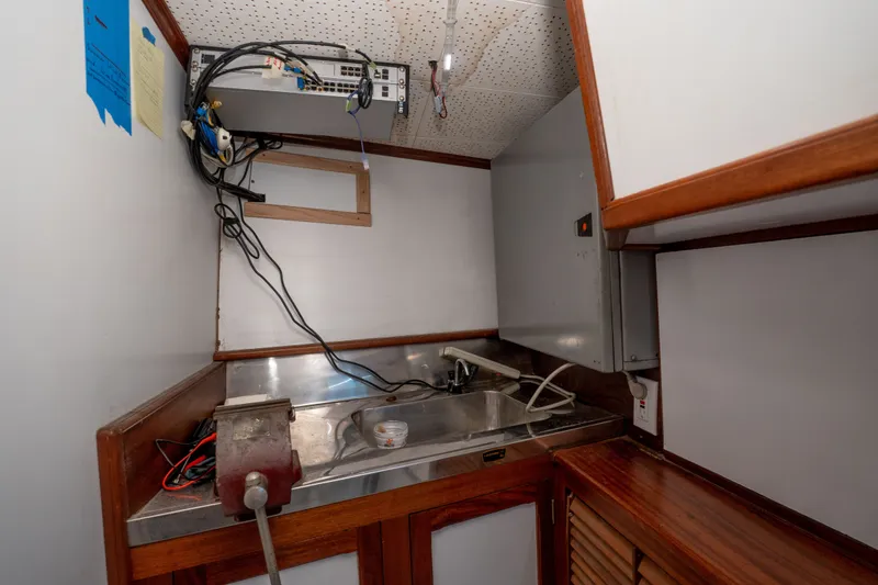 Slide: The Image of Interior of 1981 Thackwray Motorsailor with sink, wiring, and wooden cabinetry. - 91