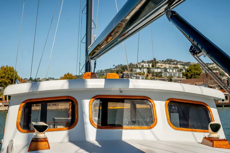 Slide: The Image of 1981 Thackwray Motorsailor boat with wooden accents, docked near waterfront buildings. - 45