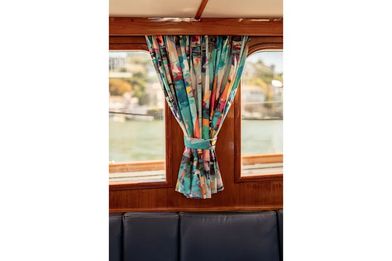 Slide: The Image of Colorful curtains on a 1981 Thackwray Motorsailor boat window, with scenic water view. - 62