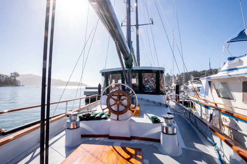 Slide: The Image of 1981 Thackwray Motorsailor yacht docked in sunny marina, featuring wooden deck and steering wheel. - 13