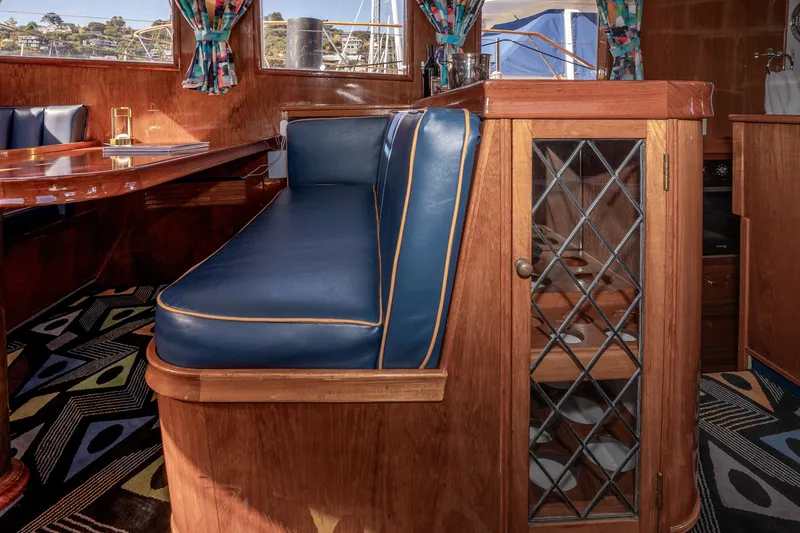 Slide: The Image of Interior of 1981 Thackwray Motorsailor with blue seating and wooden cabinetry. - 84