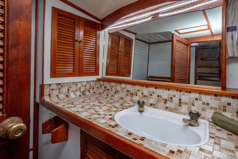 Slide: The Image of 1981 Thackwray Motorsailor bathroom with wooden cabinets and mosaic tile countertop. - 110