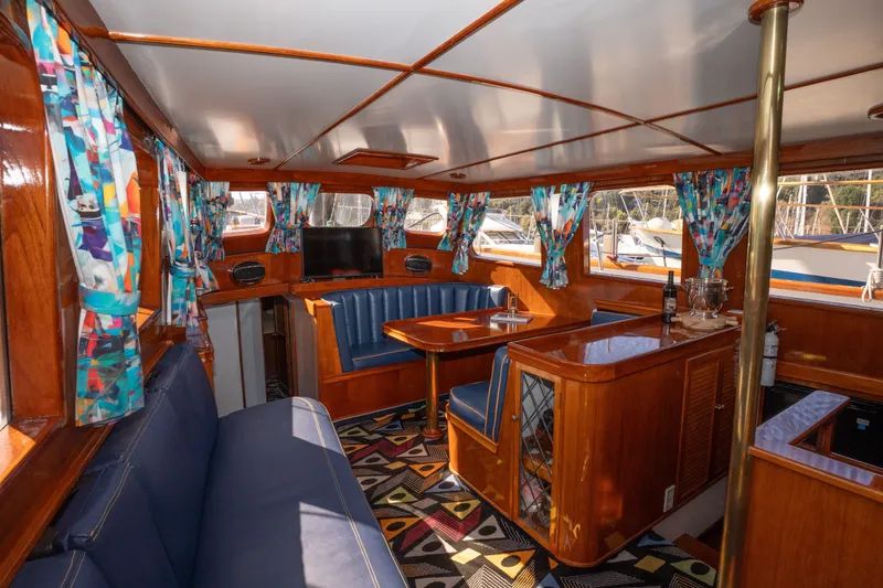 Slide: The Image of Interior of 1981 Thackwray Motorsailor with vibrant curtains and polished wood finish. - 125