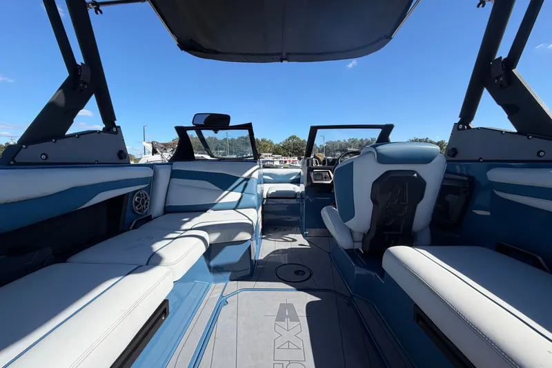 Slide: The Image of Interior of 2023 Axis T220 boat with blue and white seating under a clear sky. - 18