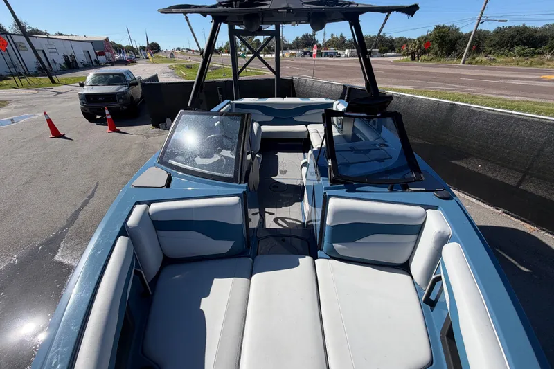 Slide: The Image of 2023 Axis T220 boat with spacious seating, parked outdoors on a sunny day. - 49