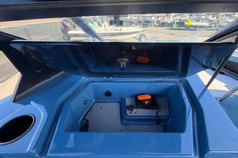 Slide: The Image of 2023 Axis T220 boat storage compartment with open lid and accessories. - 23
