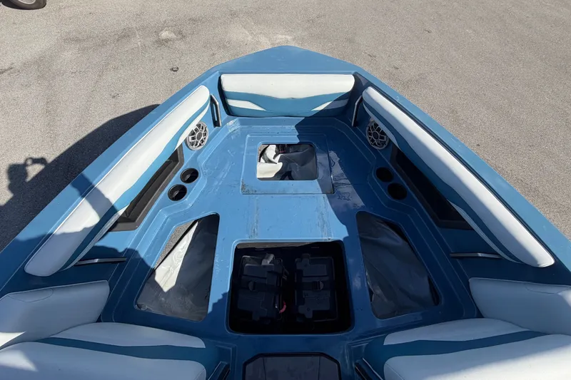 Slide: The Image of The image shows the bow of a 2023 Axis T220 boat with blue upholstery and speakers. - 47