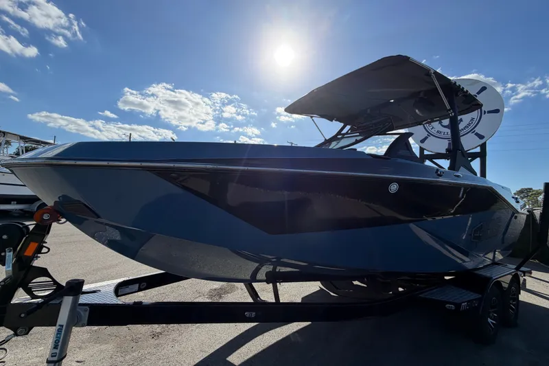 Slide: The Image of 2023 Axis T220 boat on trailer under bright sunlit sky. - 10