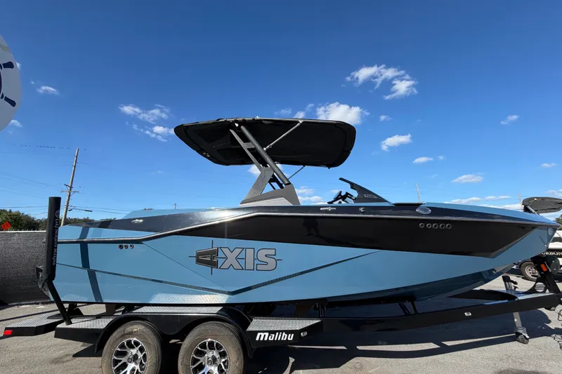 Slide: The Image of 2023 Axis T220 boat on trailer under clear blue sky. - 2