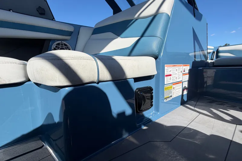 Slide: The Image of 2023 Axis T220 boat interior with blue and white seating, safety labels visible. - 25
