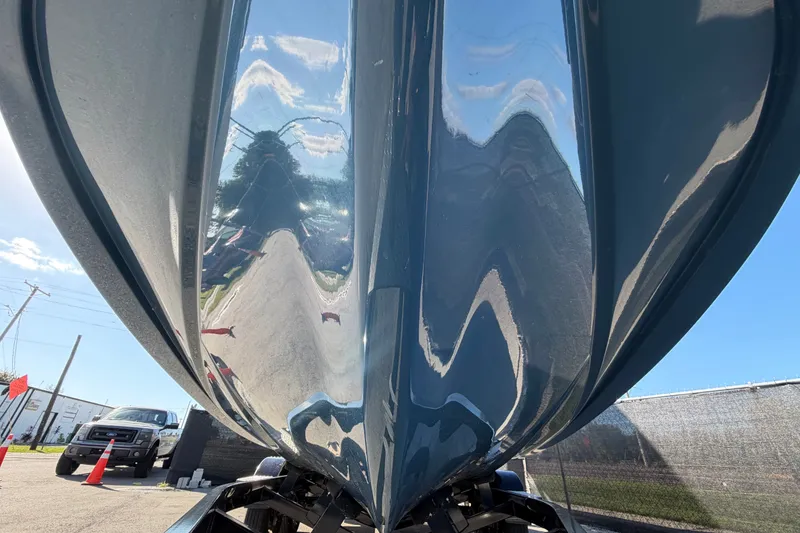 Slide: The Image of 2023 Axis T220 boat hull reflecting sky and surroundings, parked outdoors. - 12