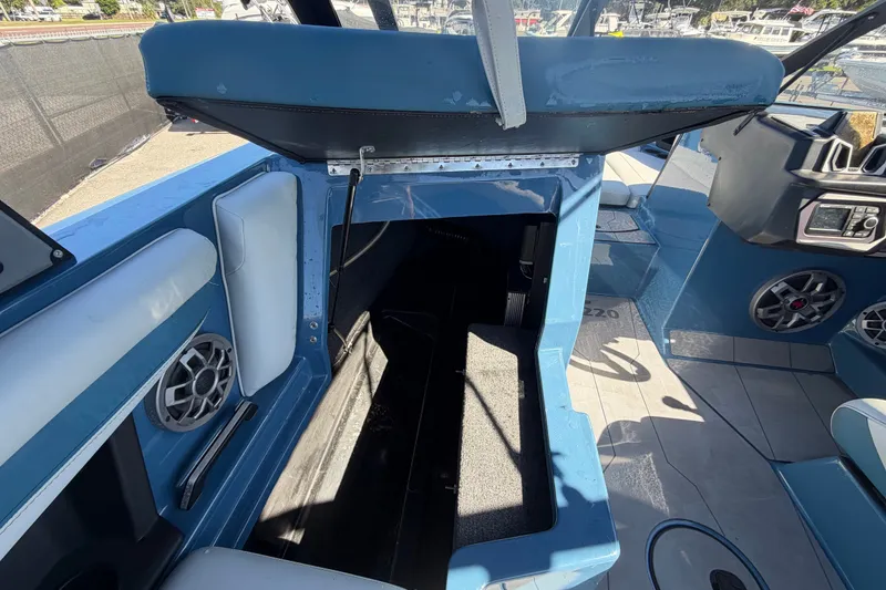 Slide: The Image of 2023 Axis T220 boat interior with open storage compartment and speaker system. - 21