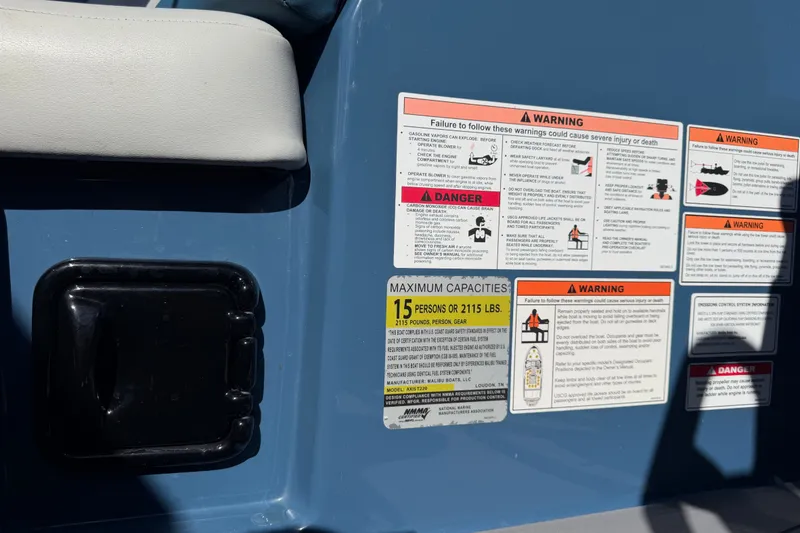 Slide: The Image of 2023 Axis T220 boat warning labels and capacity information, showing safety instructions and maximum load limits. - 26