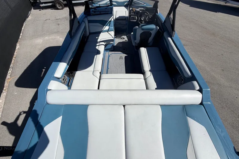 Slide: The Image of 2023 Axis T220 boat interior with blue and white seating, steering wheel visible. - 14