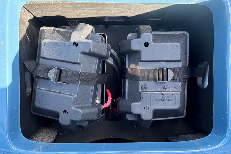 Slide: The Image of Two black battery boxes are secured in a blue compartment. - 48