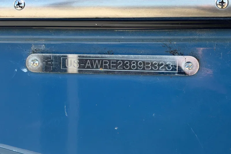 Slide: The Image of 2023 Axis T220 boat with identification plate "US-AWRE2389B323" on blue surface. - 78