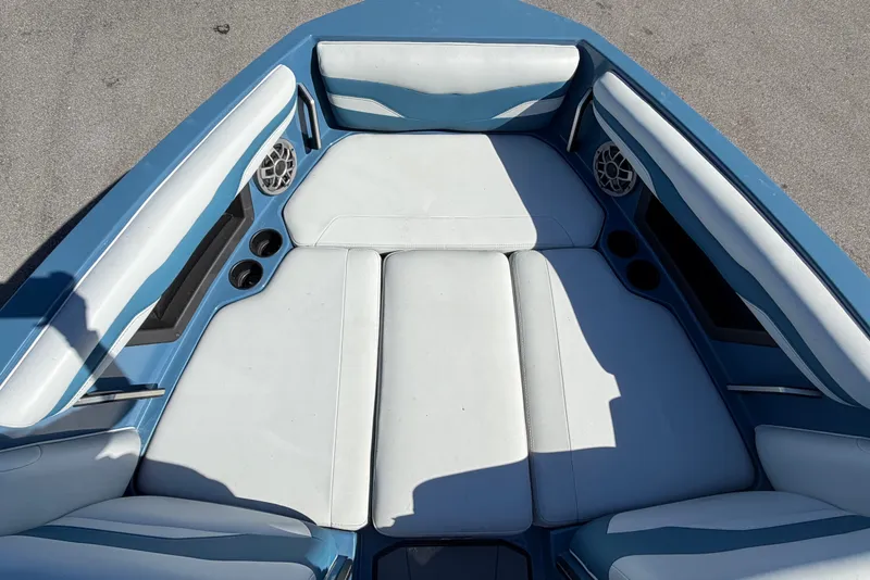 Slide: The Image of 2023 Axis T220 boat interior with blue and white seating, cup holders, and speakers. - 45