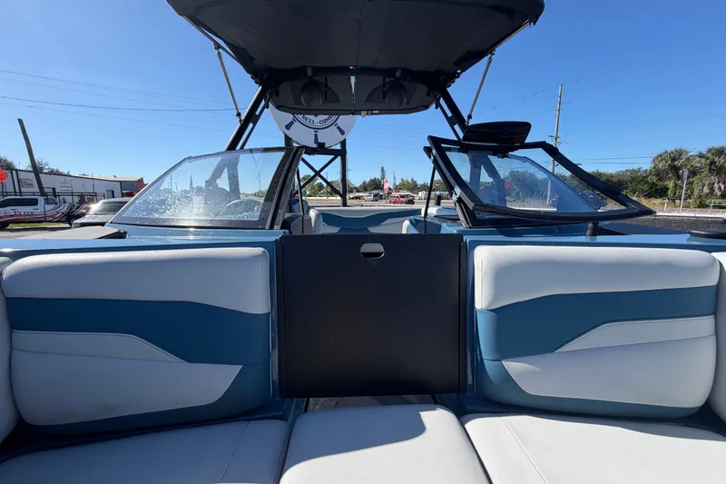 Slide: The Image of 2023 Axis T220 boat interior with blue and white seating under a clear blue sky. - 51