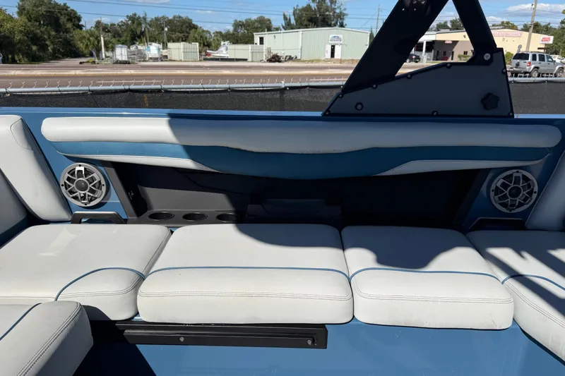 Slide: The Image of 2023 Axis T220 boat interior with blue and white seating, speakers, and cup holders. - 56