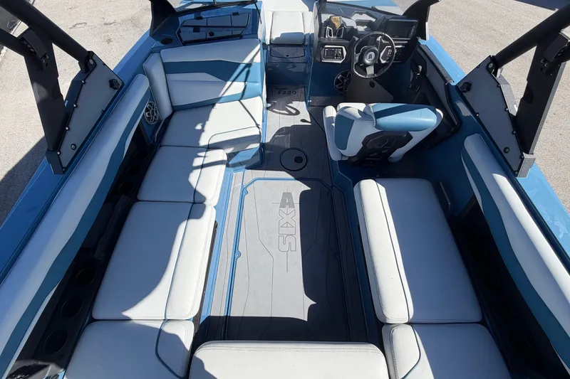 Slide: The Image of Interior of a 2023 Axis T220 boat with blue and white seating and a modern helm. - 17
