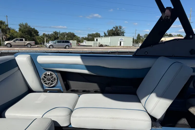 Slide: The Image of Interior of 2023 Axis T220 boat with white and blue seating, speaker, and cup holders. - 57
