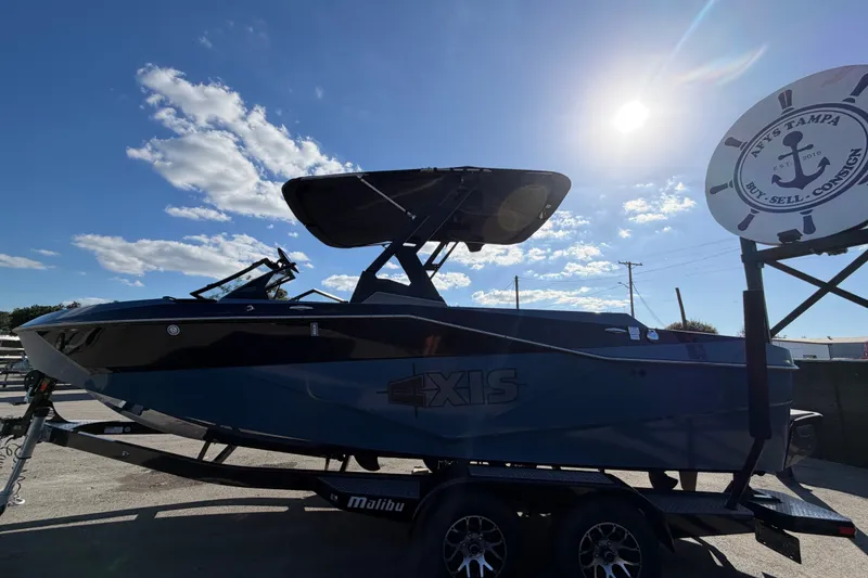 Slide: The Image of 2023 Axis T220 boat on trailer under sunny sky at dealership. - 9