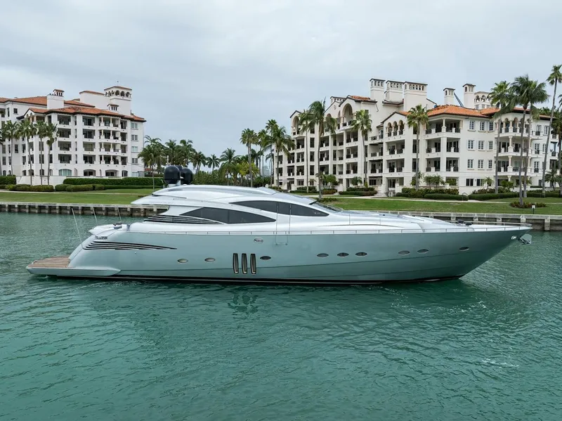 The Image of A sleek 2009 Pershing 90 yacht docked in a calm harbor, with luxurious buildings in the background. - 1