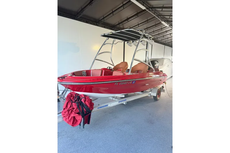 Slide: The Image of Red 2000 Cary 16 boat on trailer, under a covered area. - 6