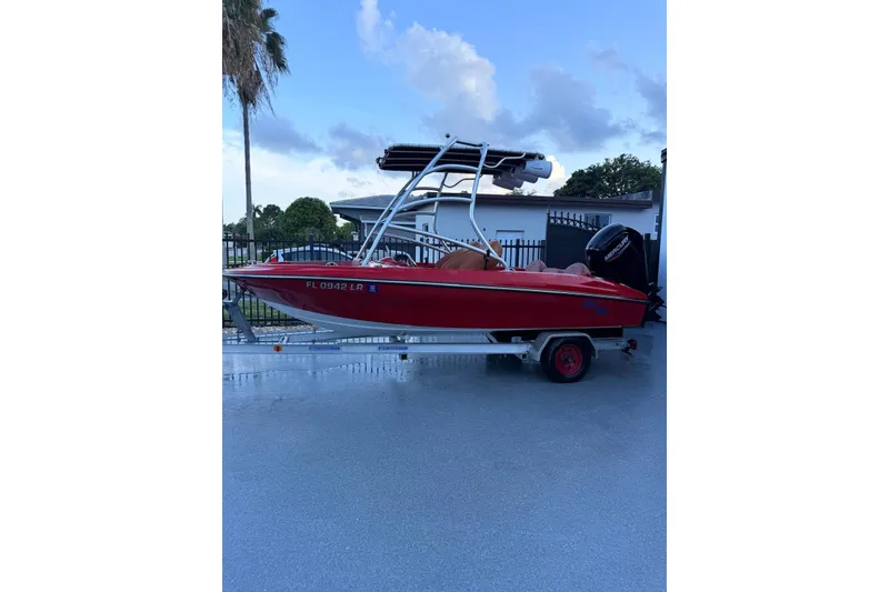 Slide: The Image of Red Cary 16 boat from 2000 on trailer, parked outdoors. - 1