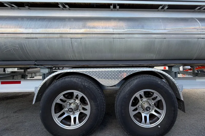 Slide: The Image of 2025 Avalon Excalibur LTD Quad Lounge on trailer, showcasing dual wheels and aluminum pontoons. - 103