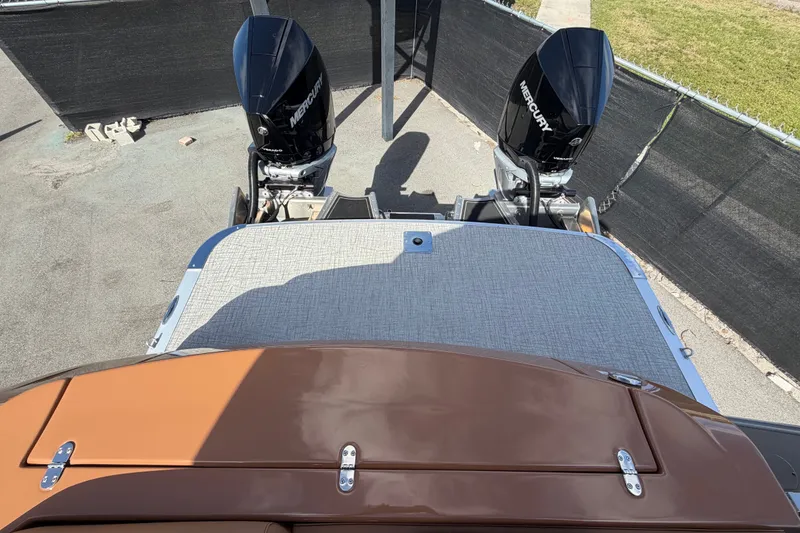 Slide: The Image of 2025 Avalon Excalibur LTD boat with dual Mercury outboard engines, rear view. - 90