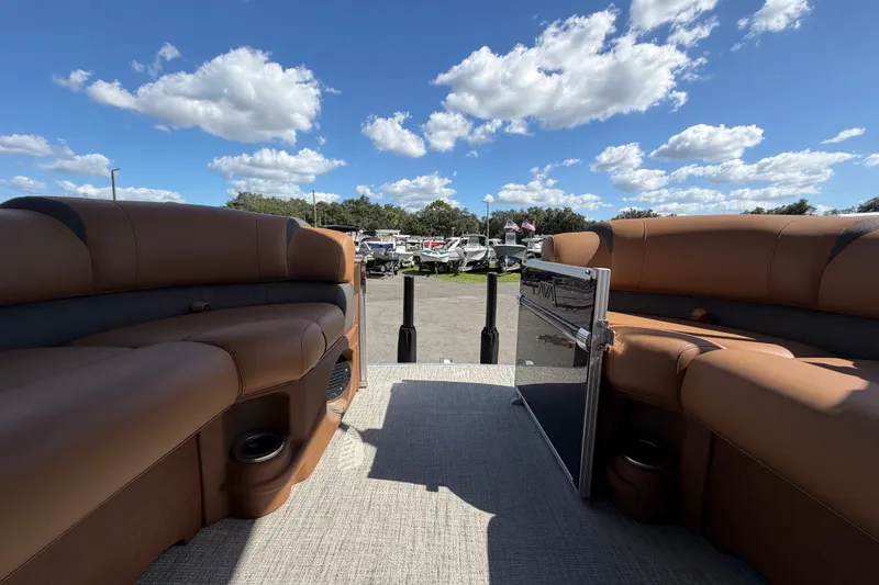 Slide: The Image of 2025 Avalon Excalibur LTD Quad Lounge boat interior with brown seating under a blue sky. - 65