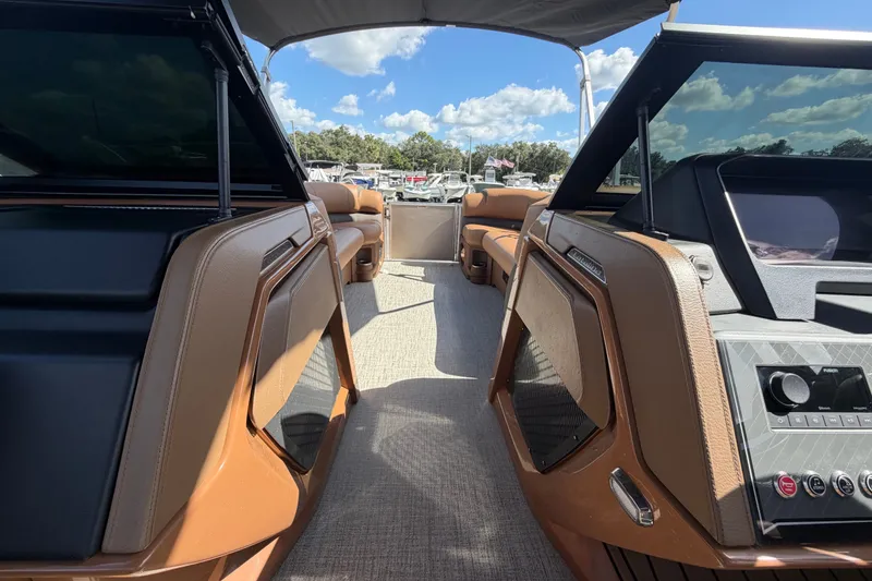 Slide: The Image of 2025 Avalon Excalibur LTD Quad Lounge boat interior with luxurious seating and modern dashboard. - 51