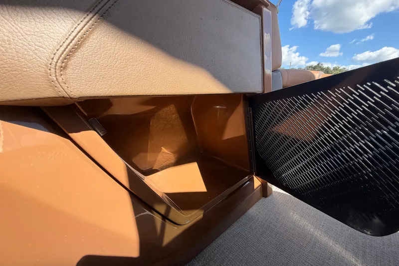 Slide: The Image of Storage compartment in 2025 Avalon Excalibur LTD Quad Lounge boat, featuring beige leather seating. - 53
