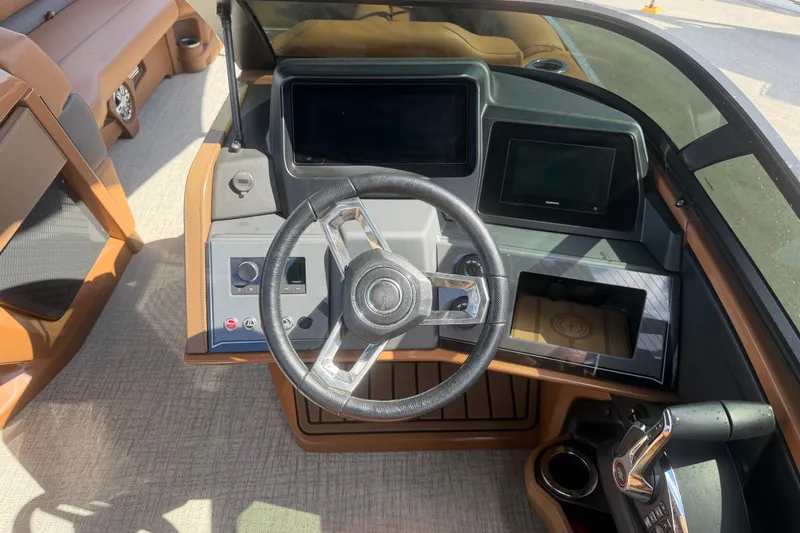 Slide: The Image of 2025 Avalon Excalibur LTD Quad Lounge boat dashboard with steering wheel and controls. - 43