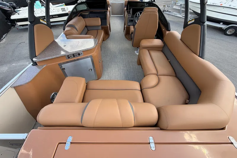 Slide: The Image of 2025 Avalon Excalibur LTD Quad Lounge boat interior with luxurious tan seating and modern amenities. - 22