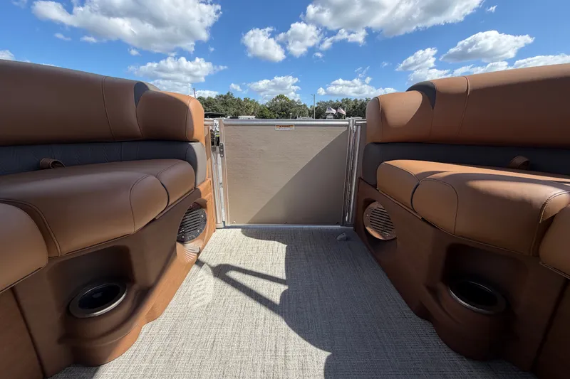 Slide: The Image of 2025 Avalon Excalibur LTD Quad Lounge interior with brown seating under a blue sky. - 64