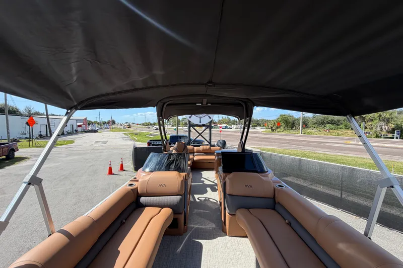 Slide: The Image of 2025 Avalon Excalibur LTD Quad Lounge boat interior with tan seating and windshield. - 68