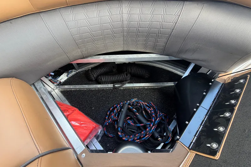 Slide: The Image of Storage compartment in the 2025 Avalon Excalibur LTD Quad Lounge Windshield with ropes and accessories. - 59