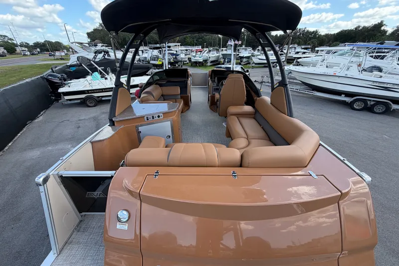 Slide: The Image of 2025 Avalon Excalibur LTD Quad Lounge boat with tan seating and black canopy. - 17