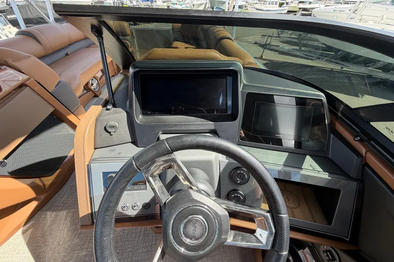 Slide: The Image of Interior view of 2025 Avalon Excalibur LTD Quad Lounge boat dashboard and steering wheel. - 44