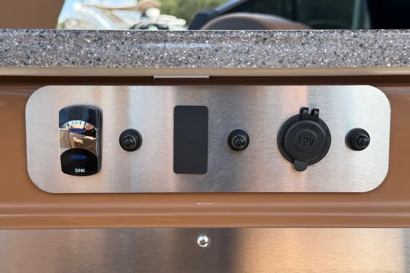 Slide: The Image of Control panel of 2025 Avalon Excalibur LTD Quad Lounge boat with sink and 12V outlet. - 26