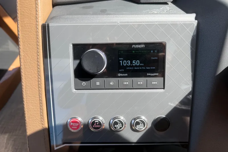 Slide: The Image of Control panel of 2025 Avalon Excalibur LTD Quad Lounge boat with radio and buttons. - 47