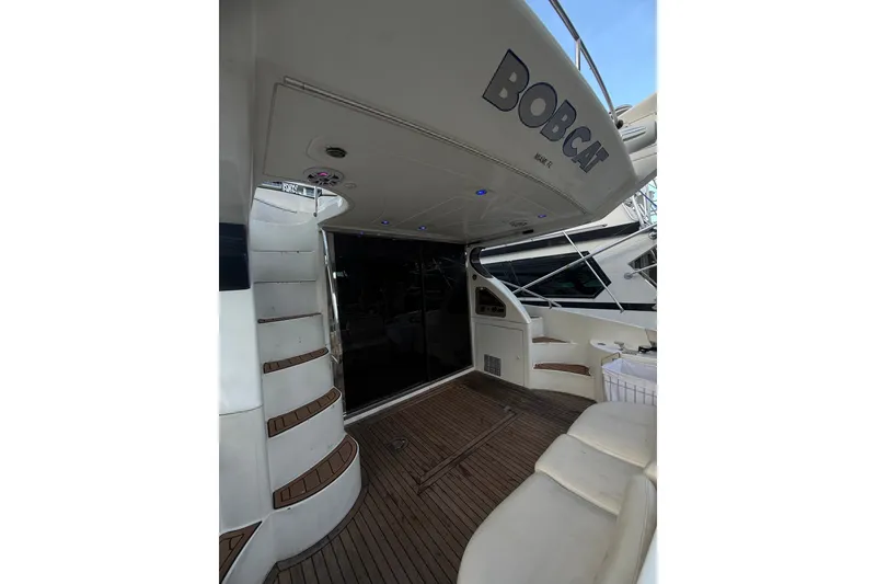 Slide: The Image of 1999 Azimut 52 yacht deck with wooden flooring and seating area. - 3