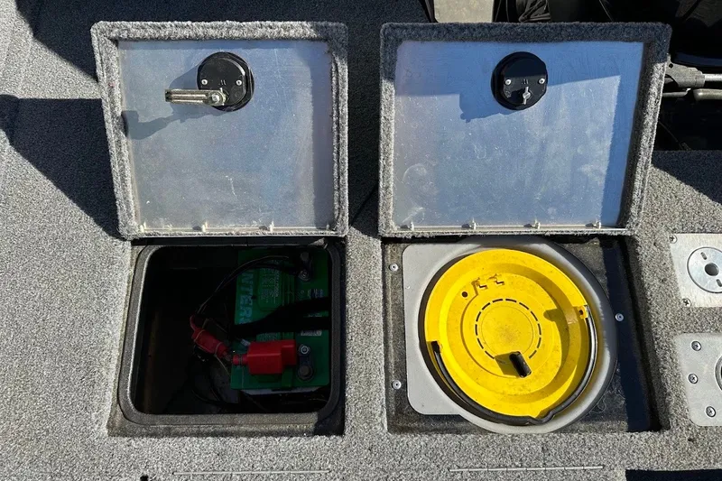 Slide: The Image of Open compartments on a 2020 Tracker Pro Guide V-175 Combo boat, revealing battery and storage. - 17