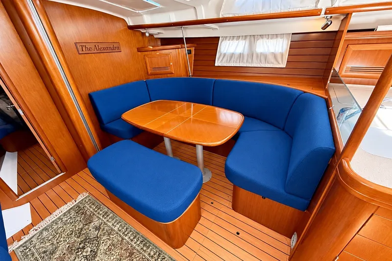 Slide: The Image of Interior of 2005 Beneteau Oceanis 473 yacht with blue seating and wooden table. - 22