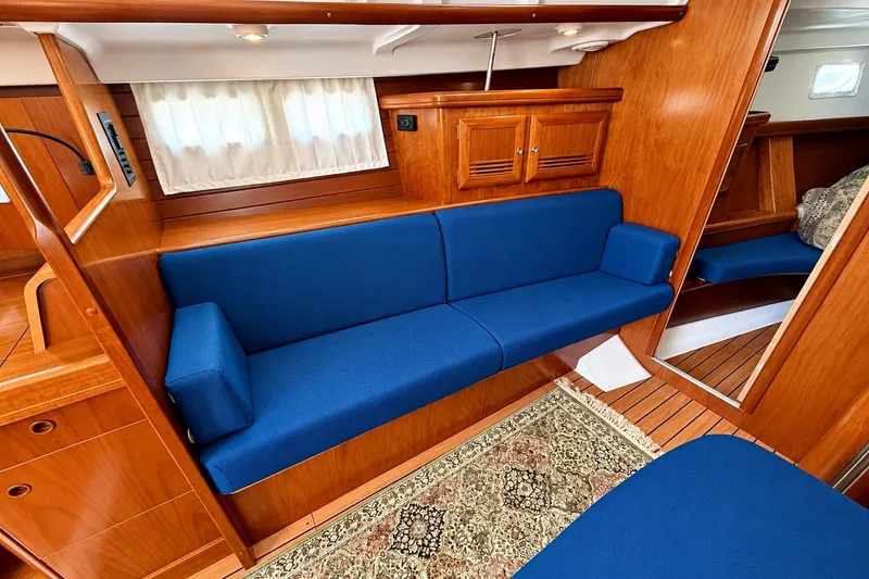 Slide: The Image of Interior of 2005 Beneteau Oceanis 473 yacht with blue seating and wooden cabinetry. - 23